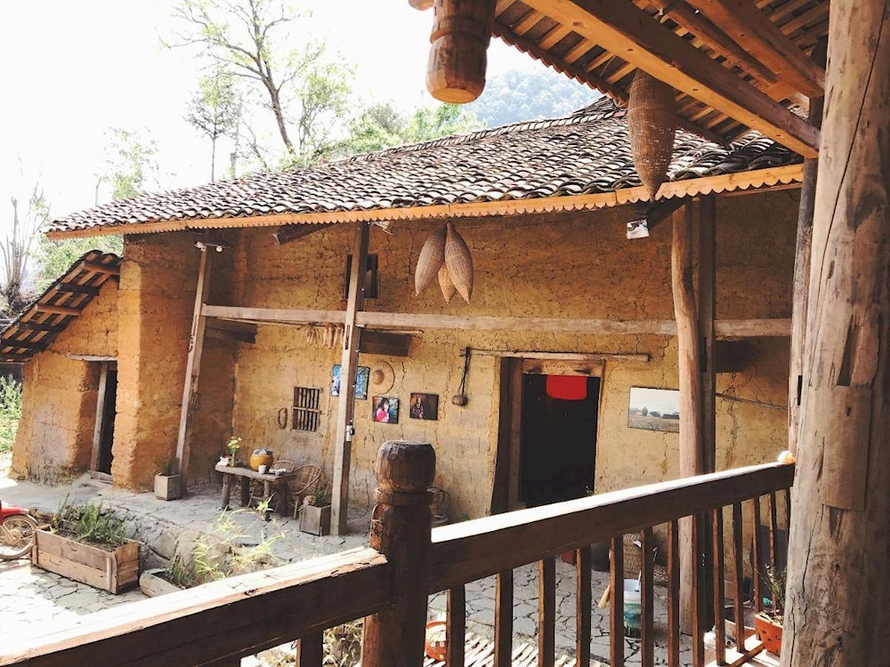 Lo Lo Eco House showcases traditional wooden stilt houses with yin-yang tile roofs, characteristic of the Lo Lo ethnic group